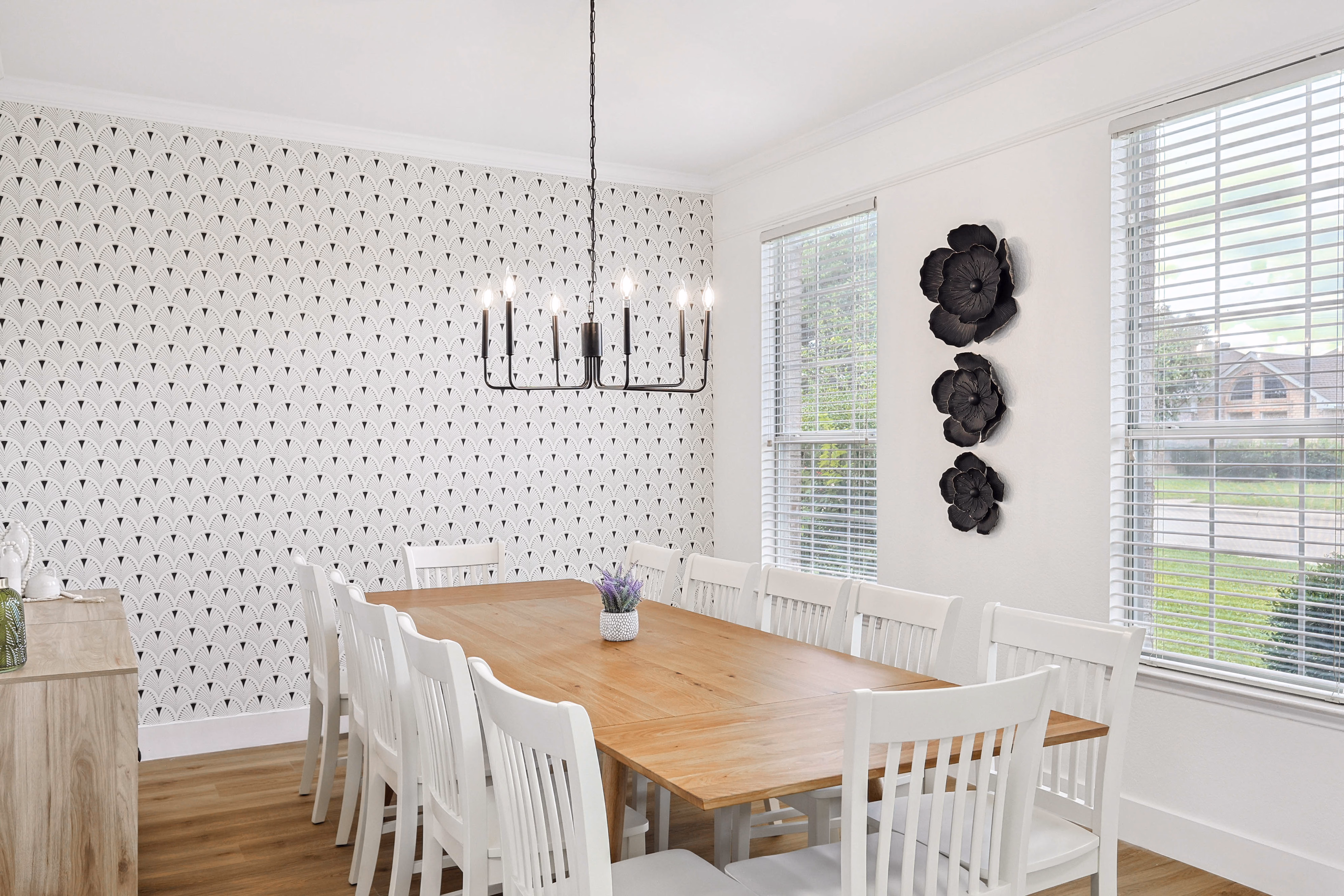 Dining room — view down the table toward the primary bedroom doorway, dandelion print over credenza.
