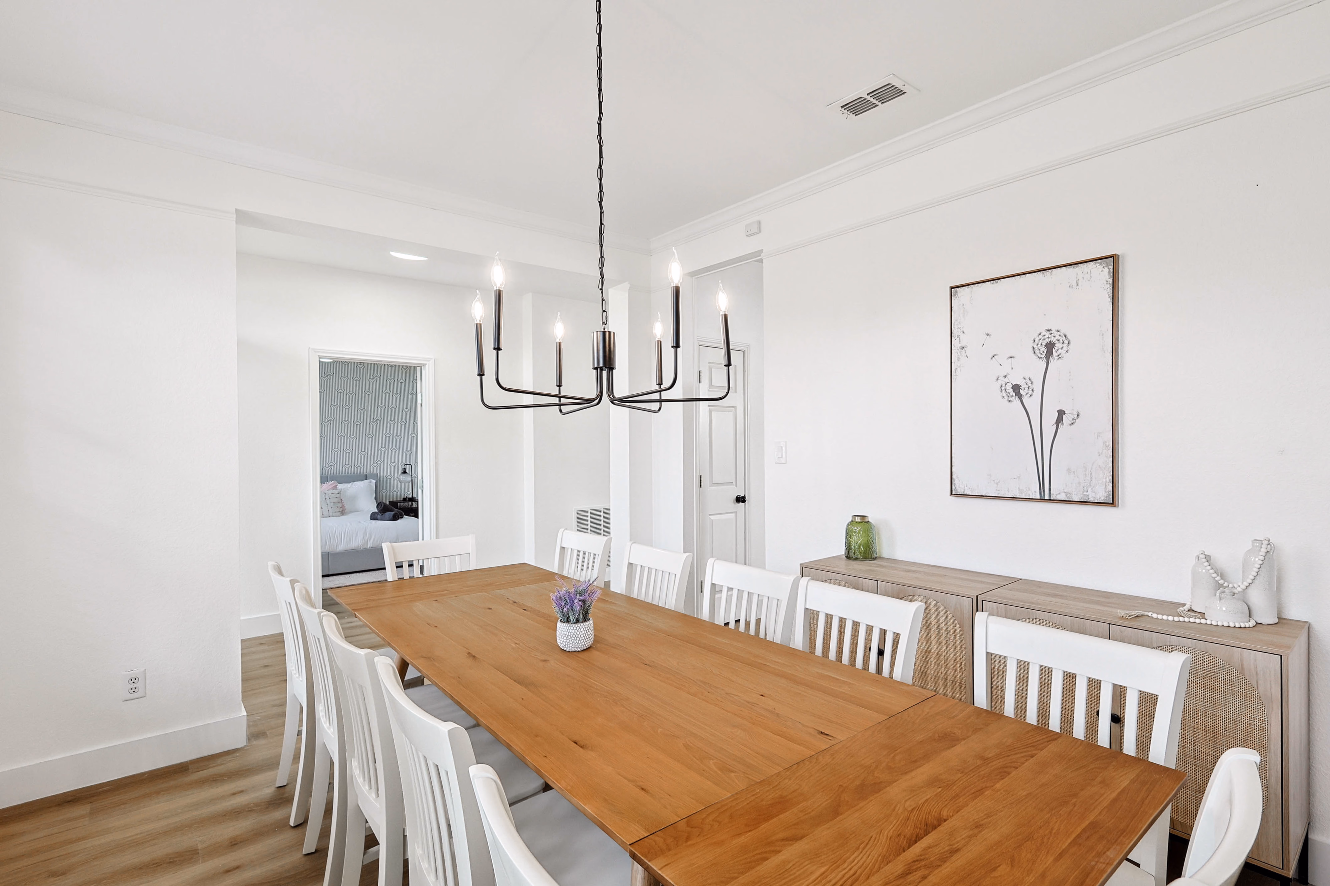 Dining room — view from foyer side toward front window, primary bedroom visible through the doorway.