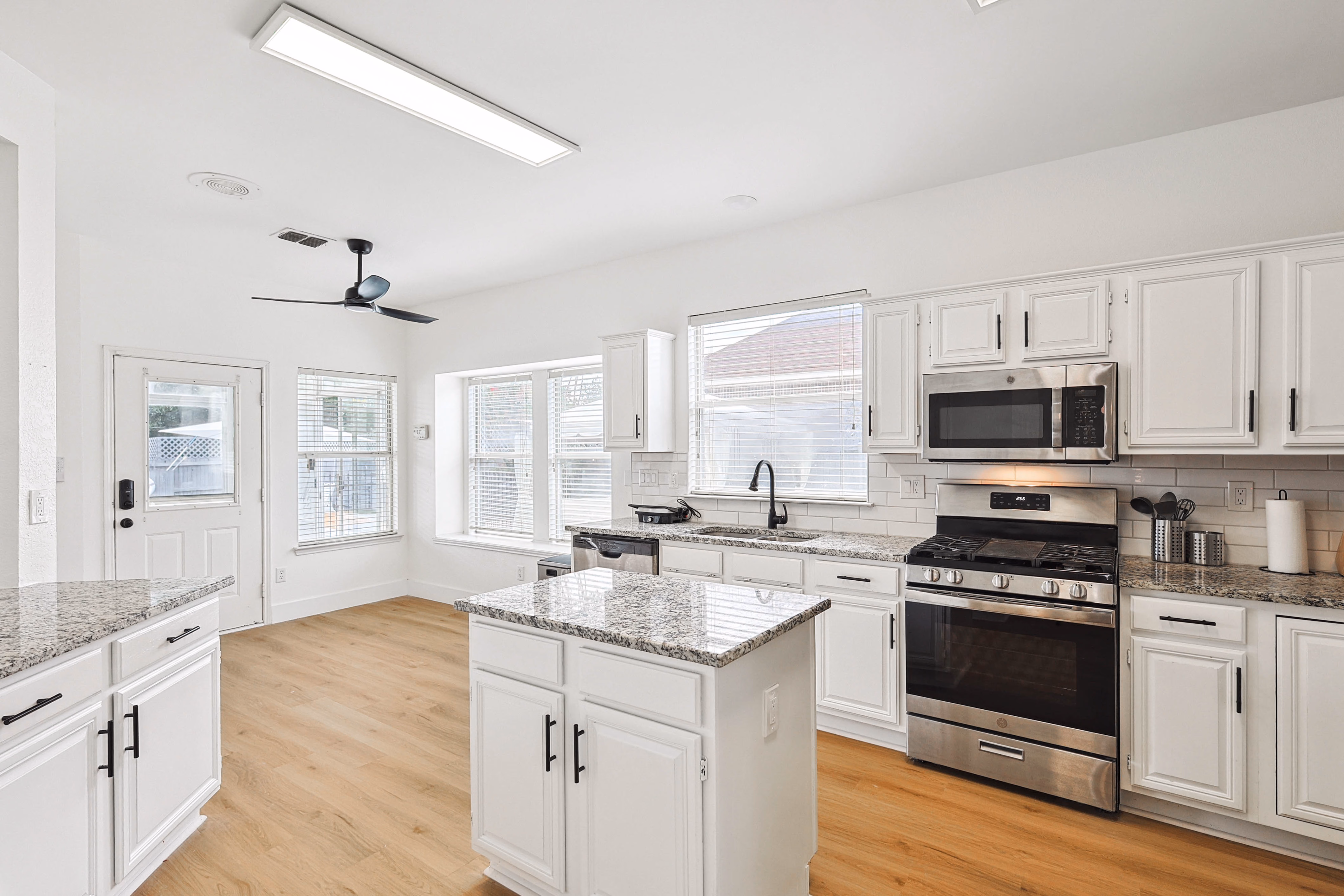 Kitchen — center island with stairwell pass-through to great room beyond.