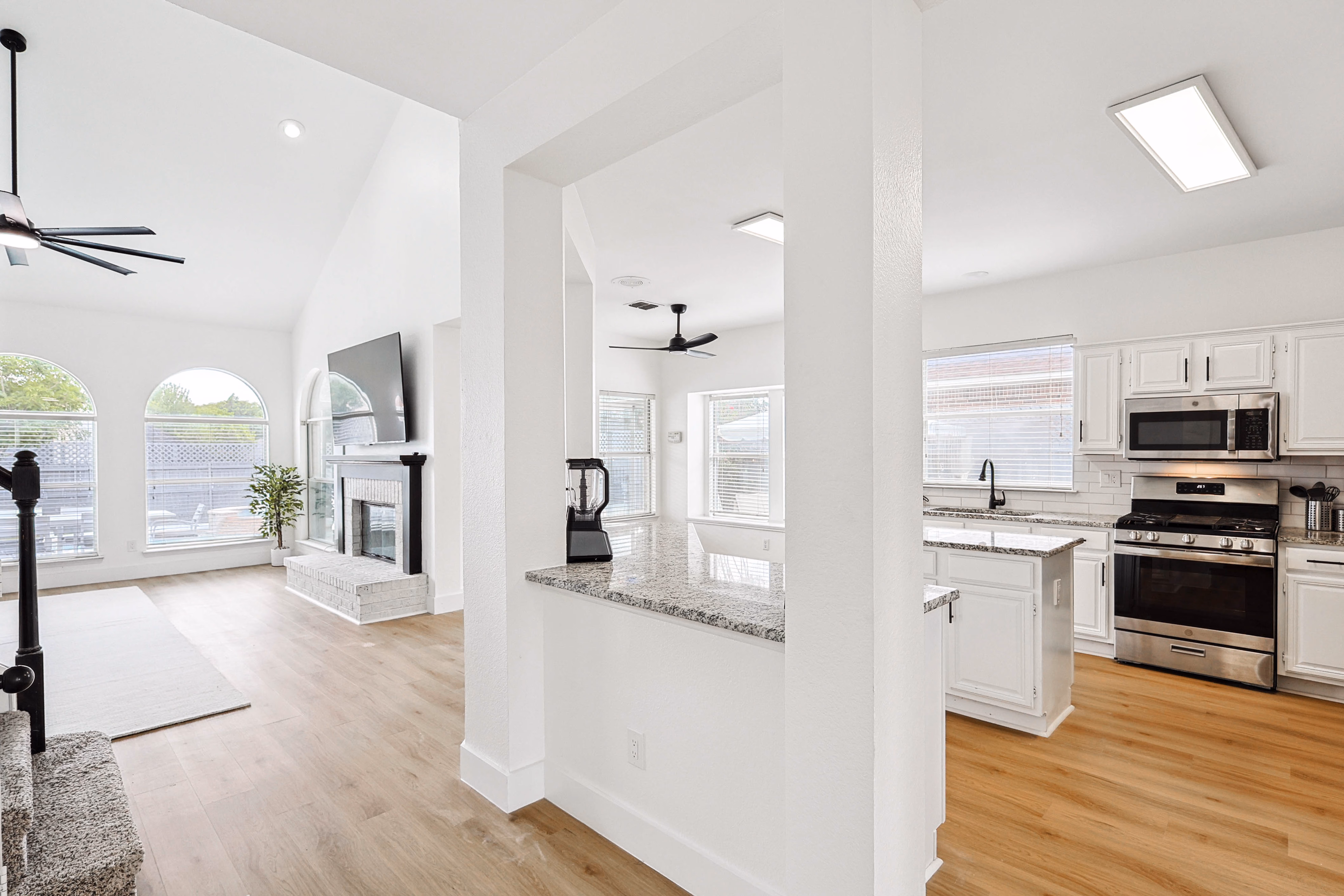 Kitchen — sink under window, gas range, subway-tile backsplash, view down counter run.