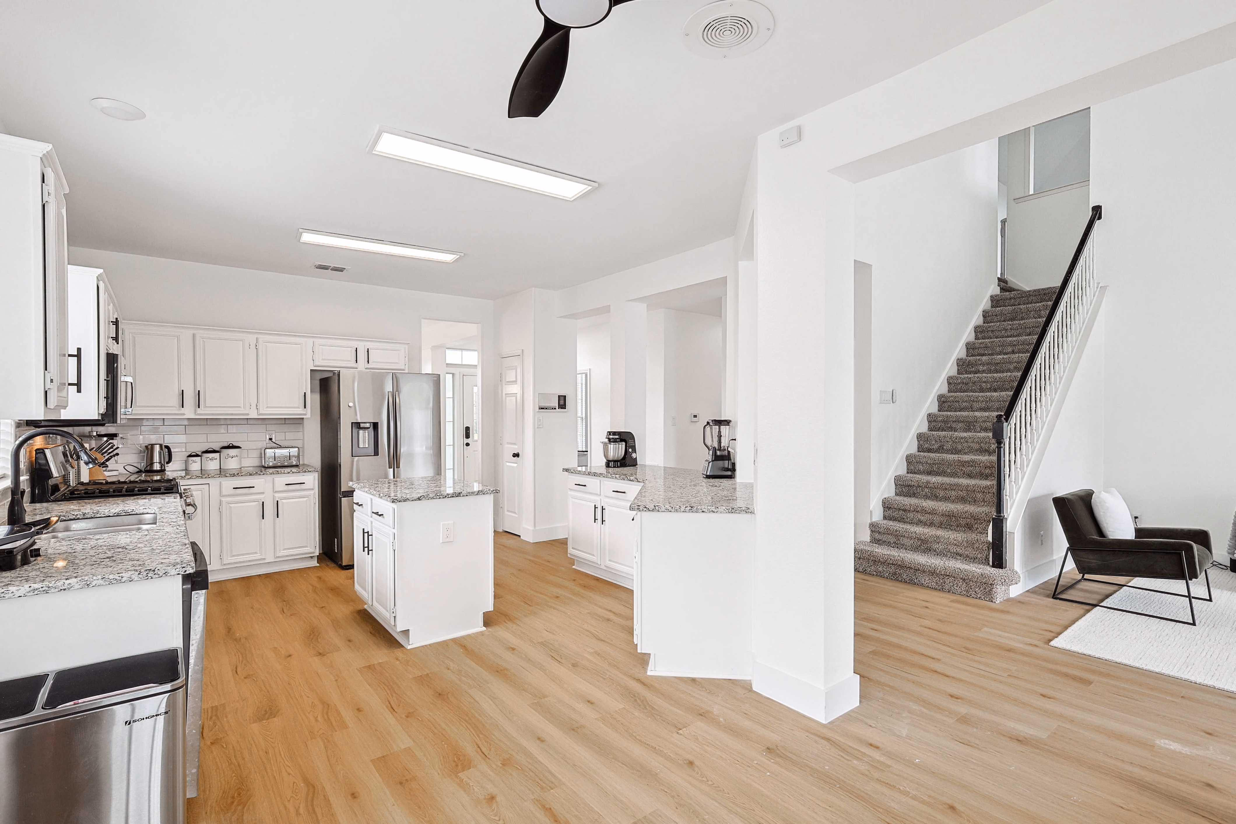 Kitchen pulled back — center island, sightline to stairs and back of great room.