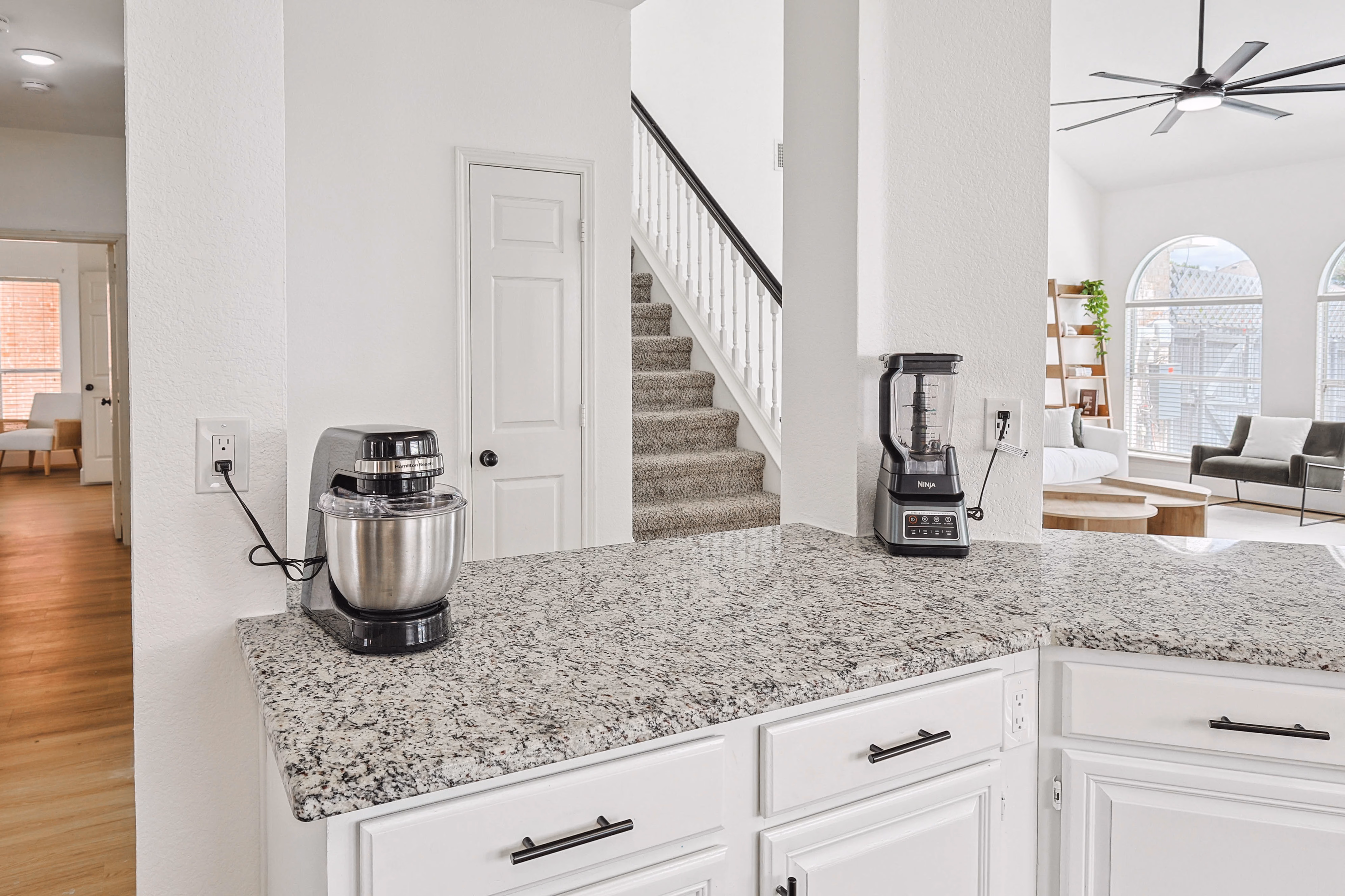 Laundry room — full-size top-load washer and front-load dryer with back exit door.
