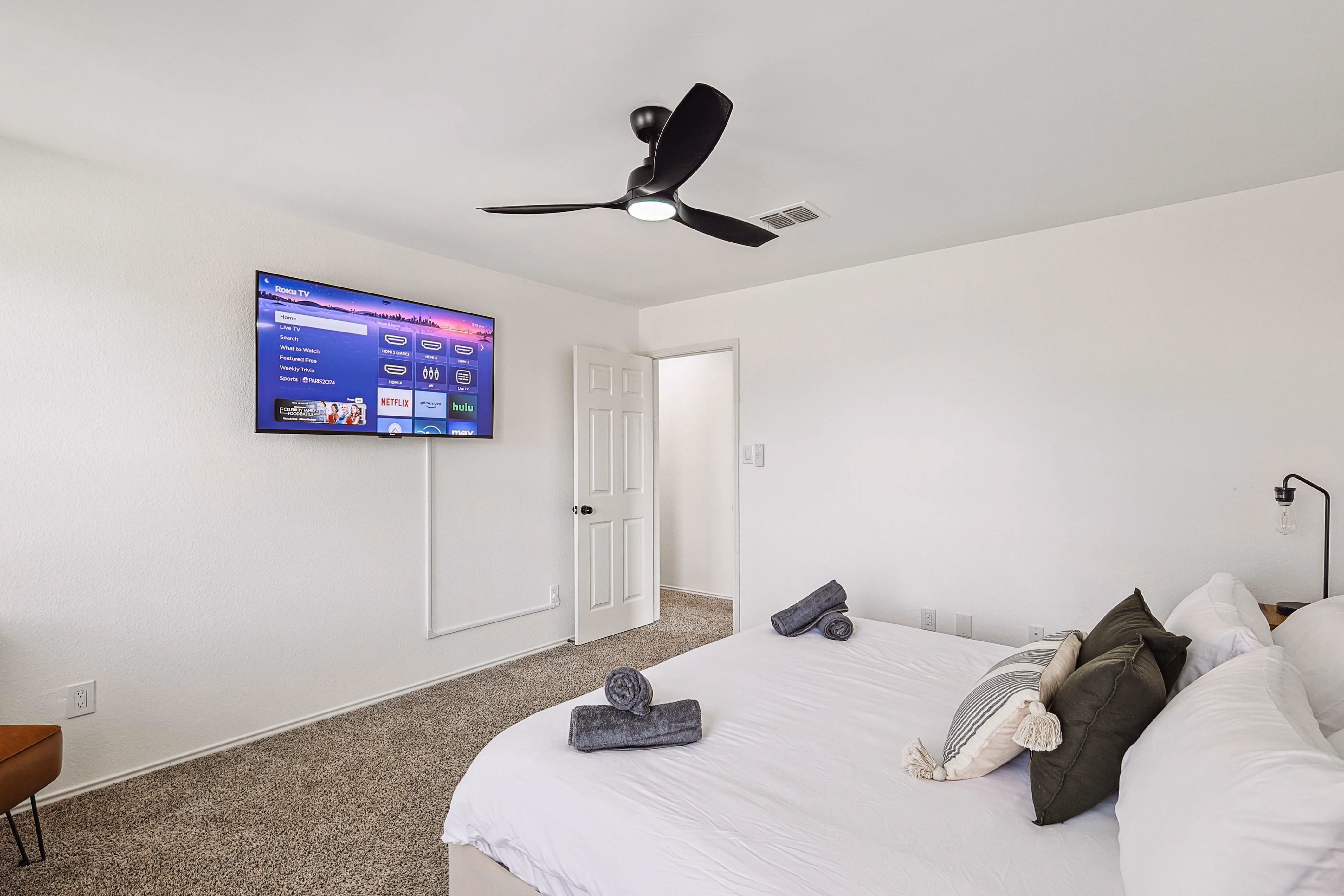 Upstairs bedroom — straight-on of the king bed with botanical-plate gallery wall.