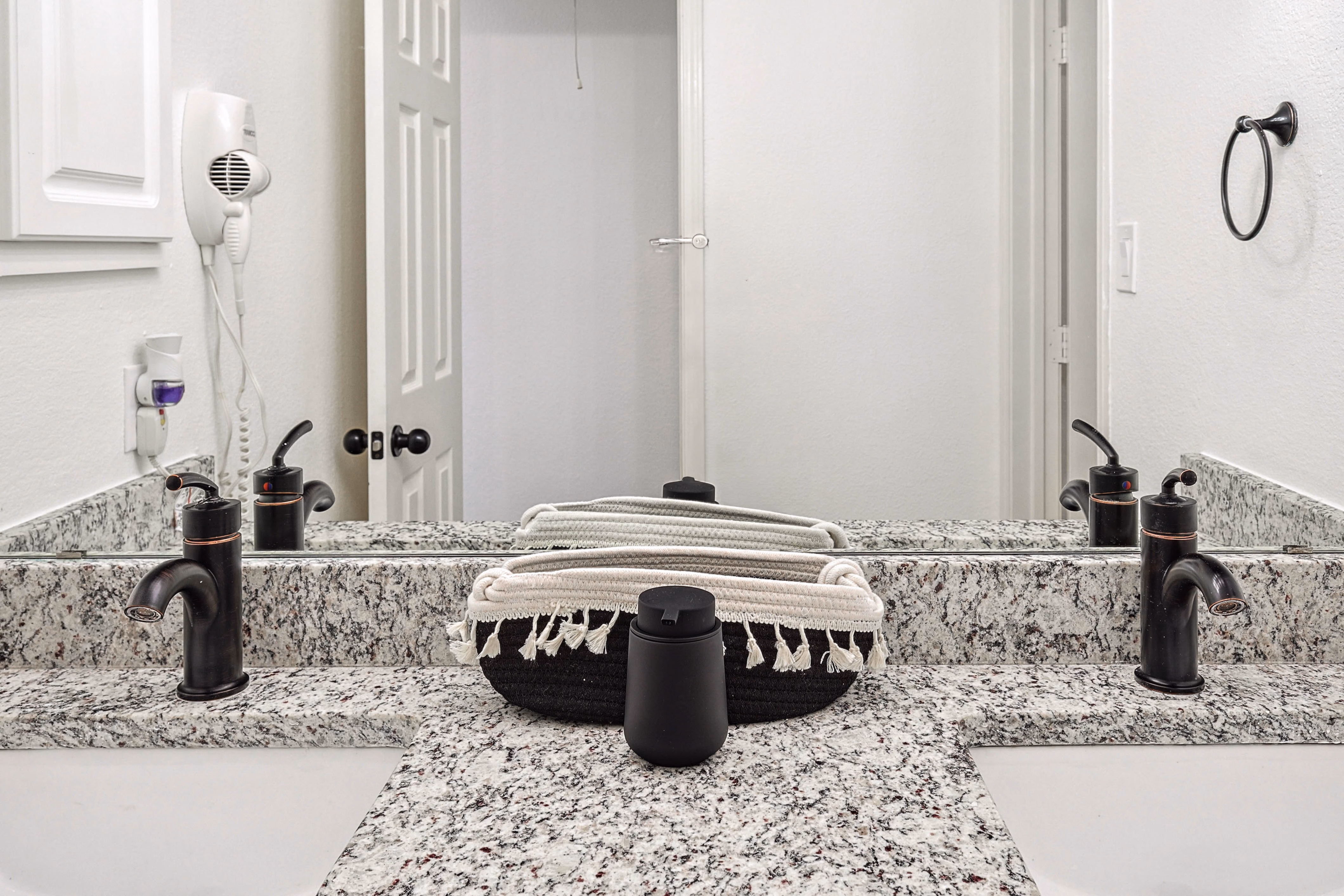 Upstairs bunk-room bathroom — close-up of granite double vanity with bronze faucets.