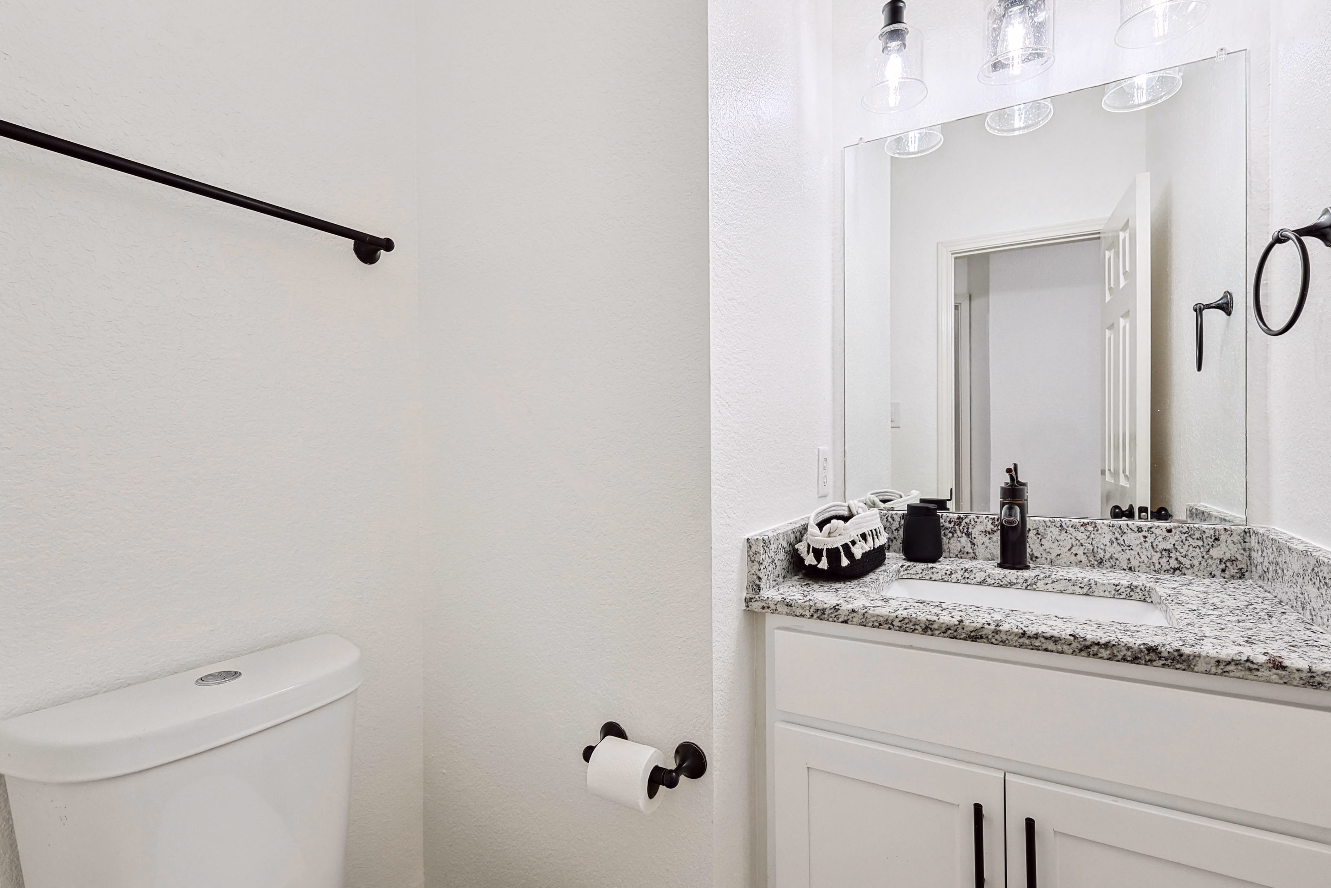 Powder room — toilet and granite vanity in compact half-bath off the hallway.