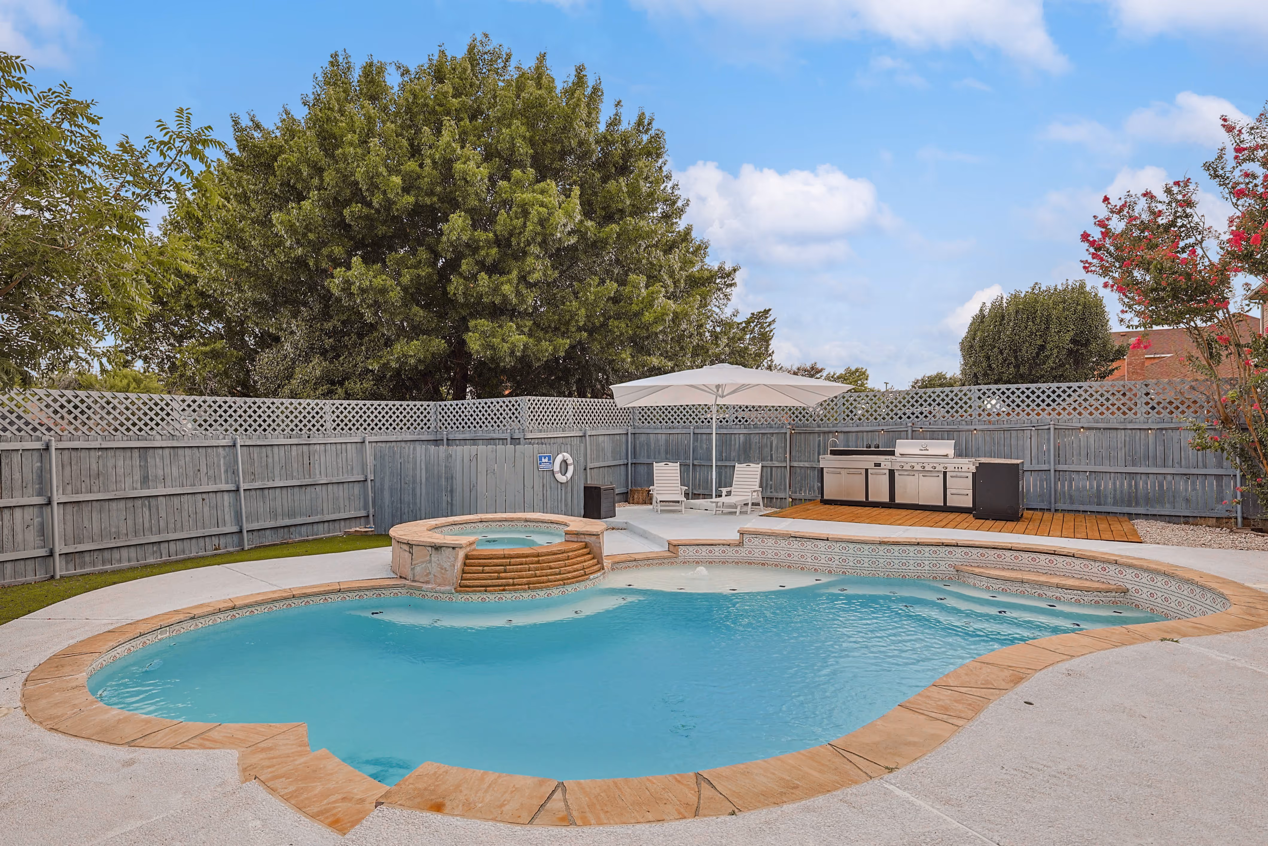 Pool — wide view with hot tub, umbrella shade and outdoor kitchen on the wood deck.
