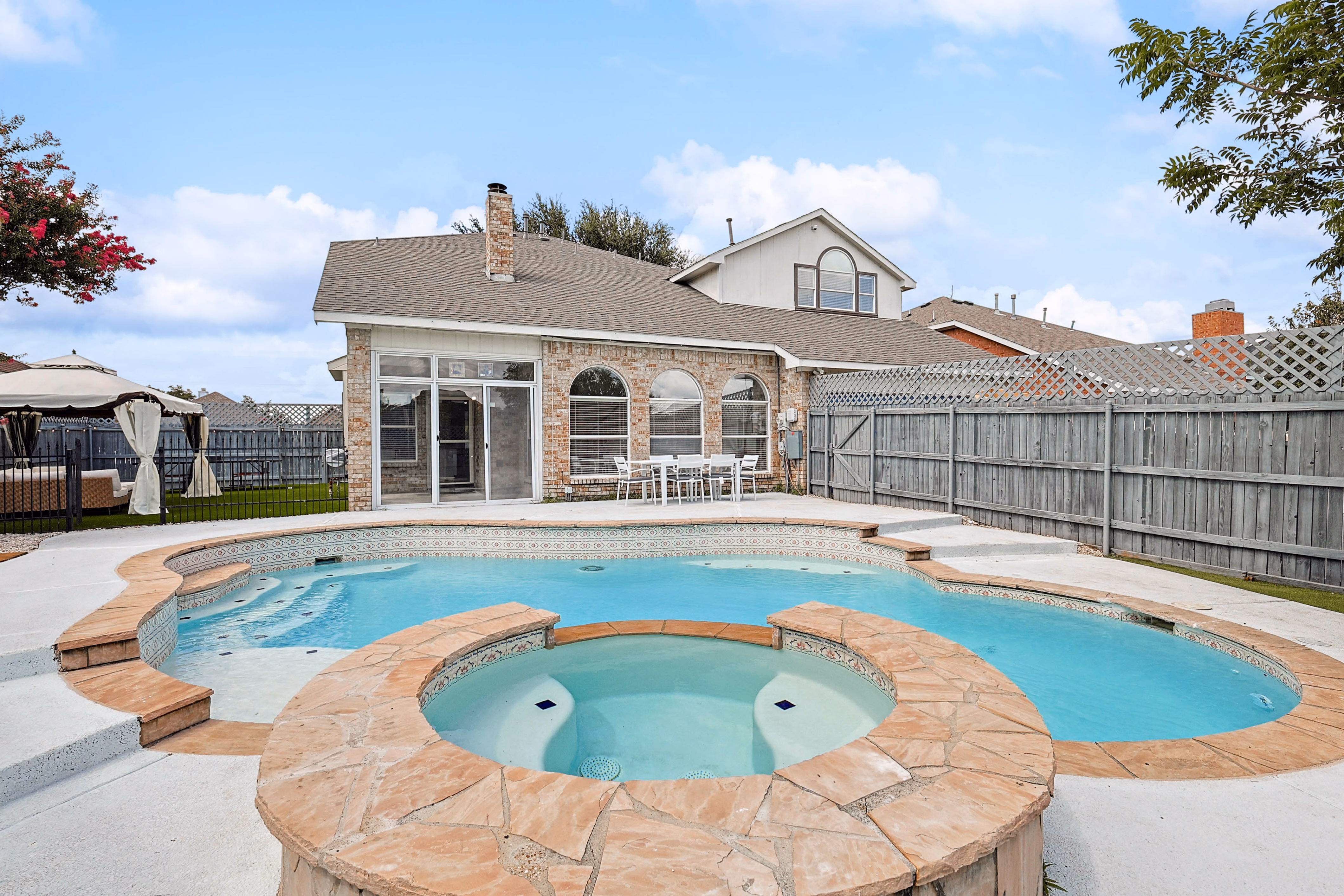 Pool — looking back at the house with chimney, screened porch and pavilion umbrella visible.
